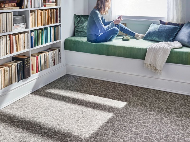 Child on bed with carpet on floor - Carpet Clearance Warehouse in Keene, NH